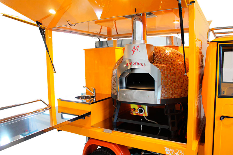 pizzeria mobile attrezzata con un forno duale alimentato a gas e legna
