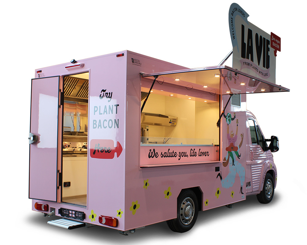 food truck vegano di colore rosa vende prodotti a base di bacon vegetale